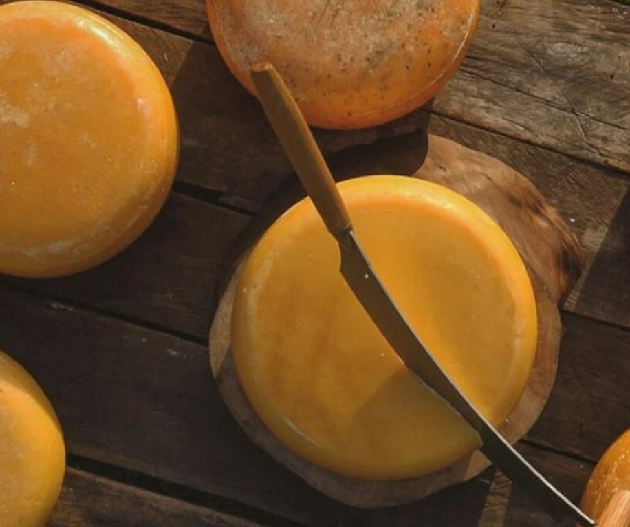 Goudas artesanais inteiros sobre a tábua de madeira, um deles sendo cortado