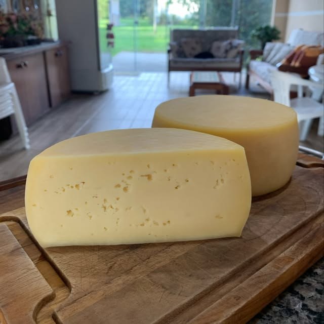 Queijo colonial da Oma inteiro e cortado sobre a tábua